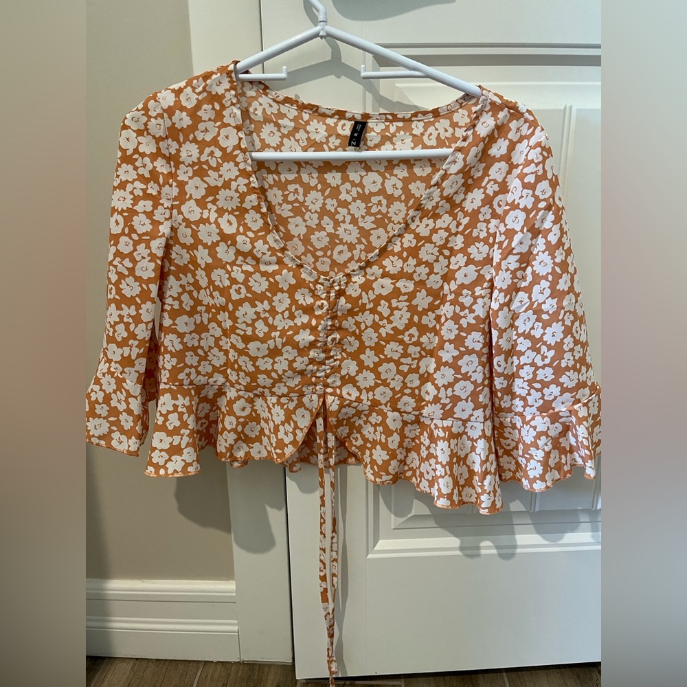 Light orange/tan quarter sleeve blouse. Adjustable front with string.